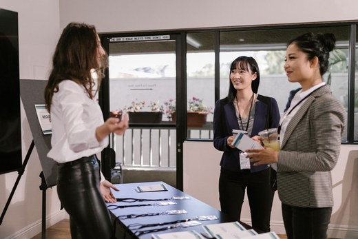 Attendees collect lanyards and badges at a conference registration table