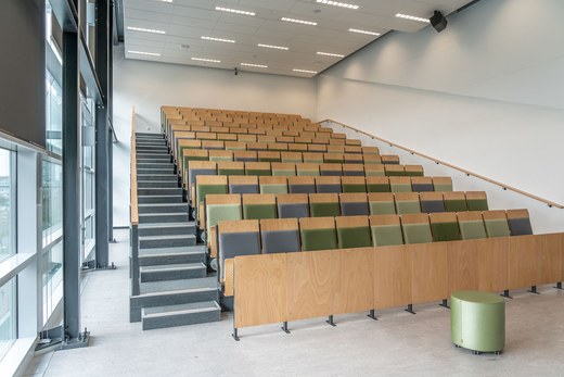 Rows of empty lecture-hall-style seating rising toward the back of a modern auditorium