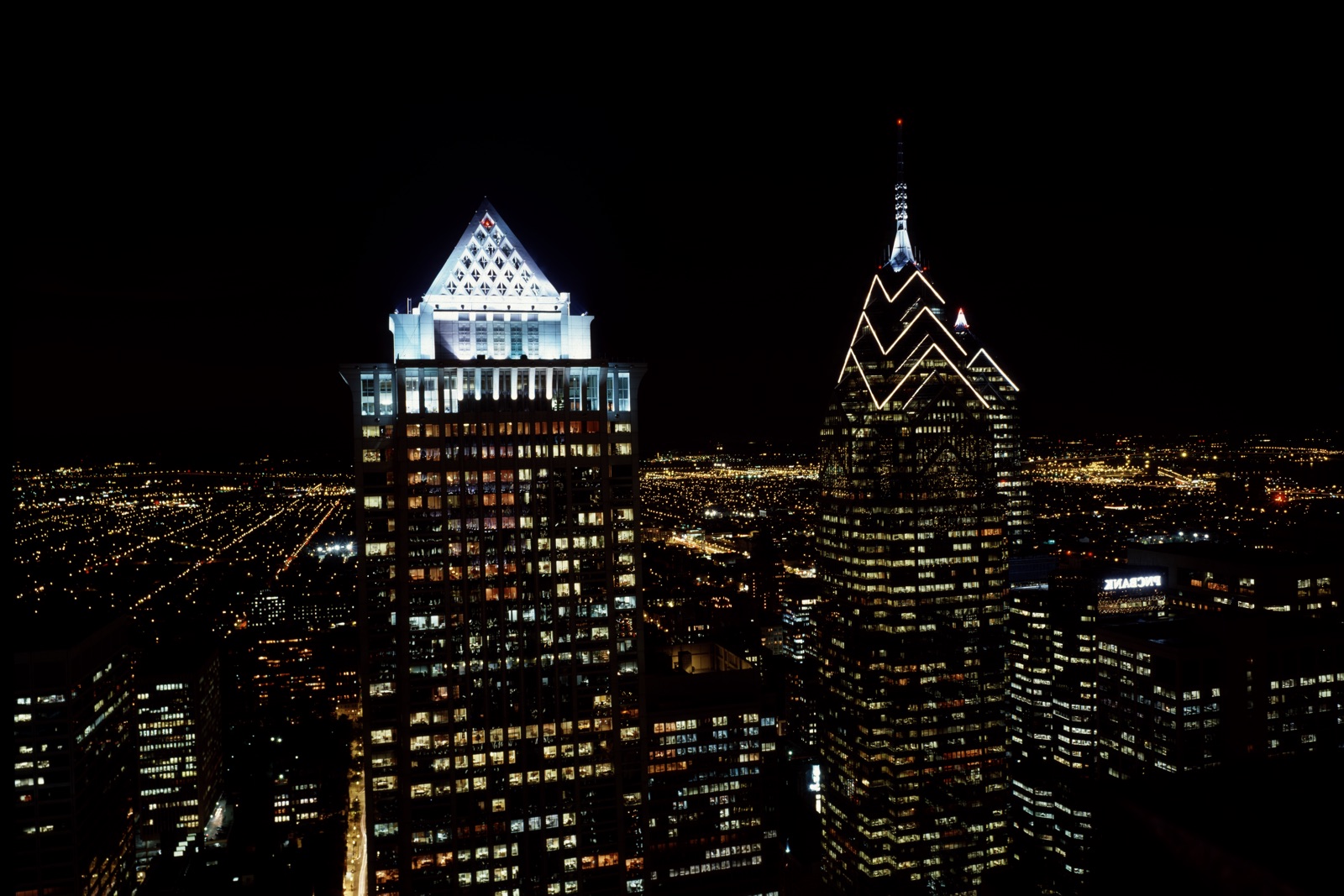 Philadelphia skyscrapers lit at night, with the spire of One Liberty Place
