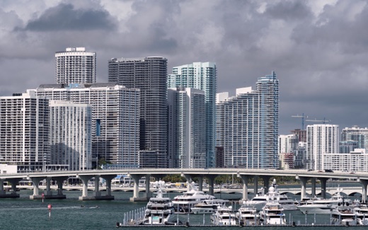 Miami high-rise towers across Biscayne Bay, with yachts moored at a marina