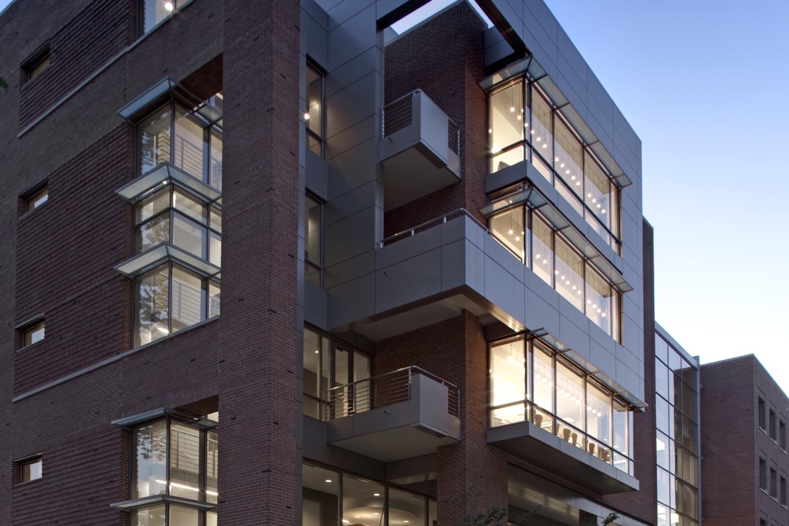 The glass-and-brick pathway to the main entrance of an FDA building on the White Oak campus at dusk