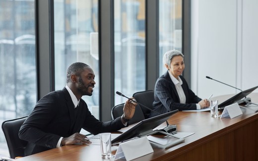 Panelists seated at a conference table answering questions during a legal and regulatory panel discussion