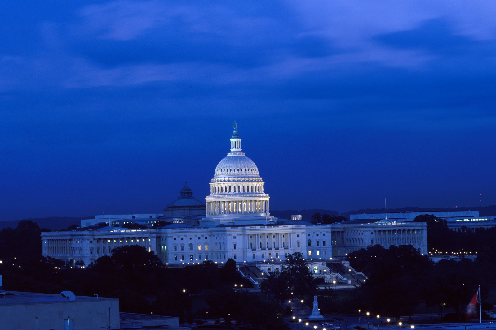 The US Capitol dome illuminated against a deep blue night sky