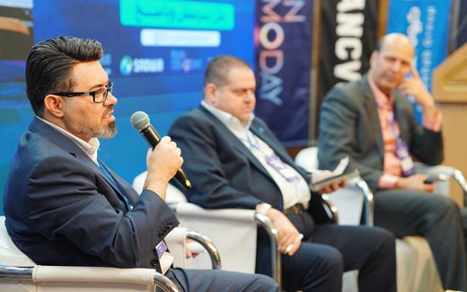 Four panelists in business attire seated on stage during a legal and regulatory conference panel discussion