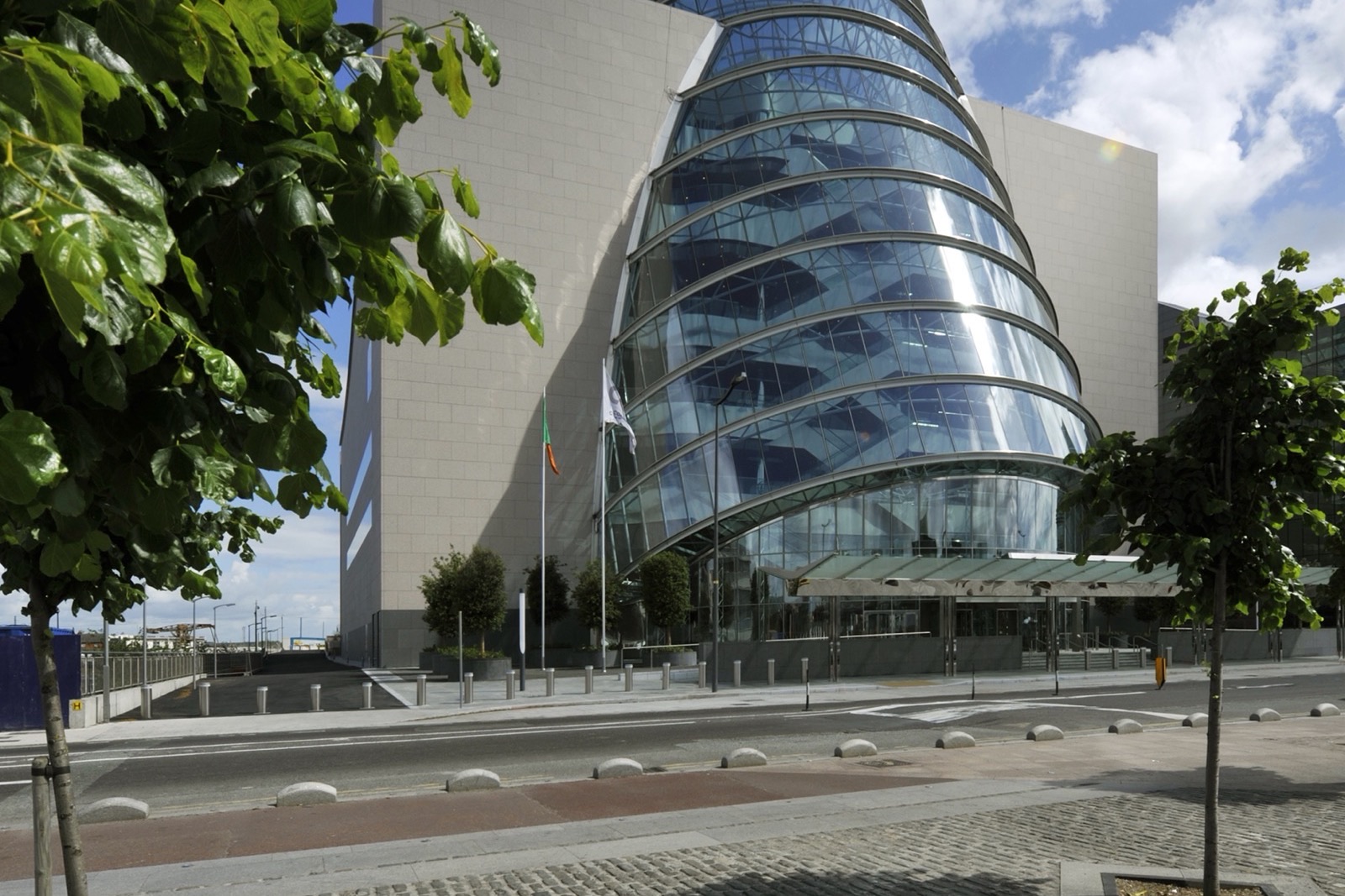 The tilted glass atrium of the Convention Centre Dublin seen from the street