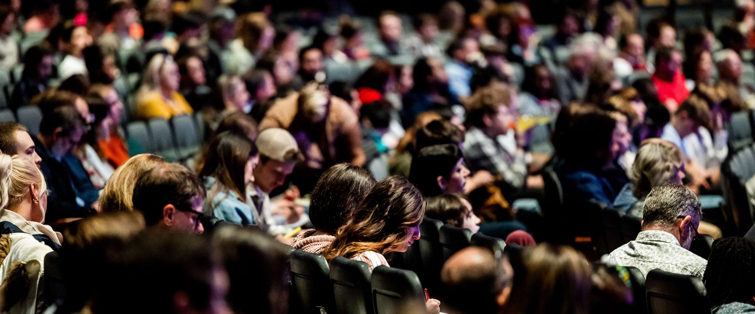 Delegates seated through a full conference auditorium