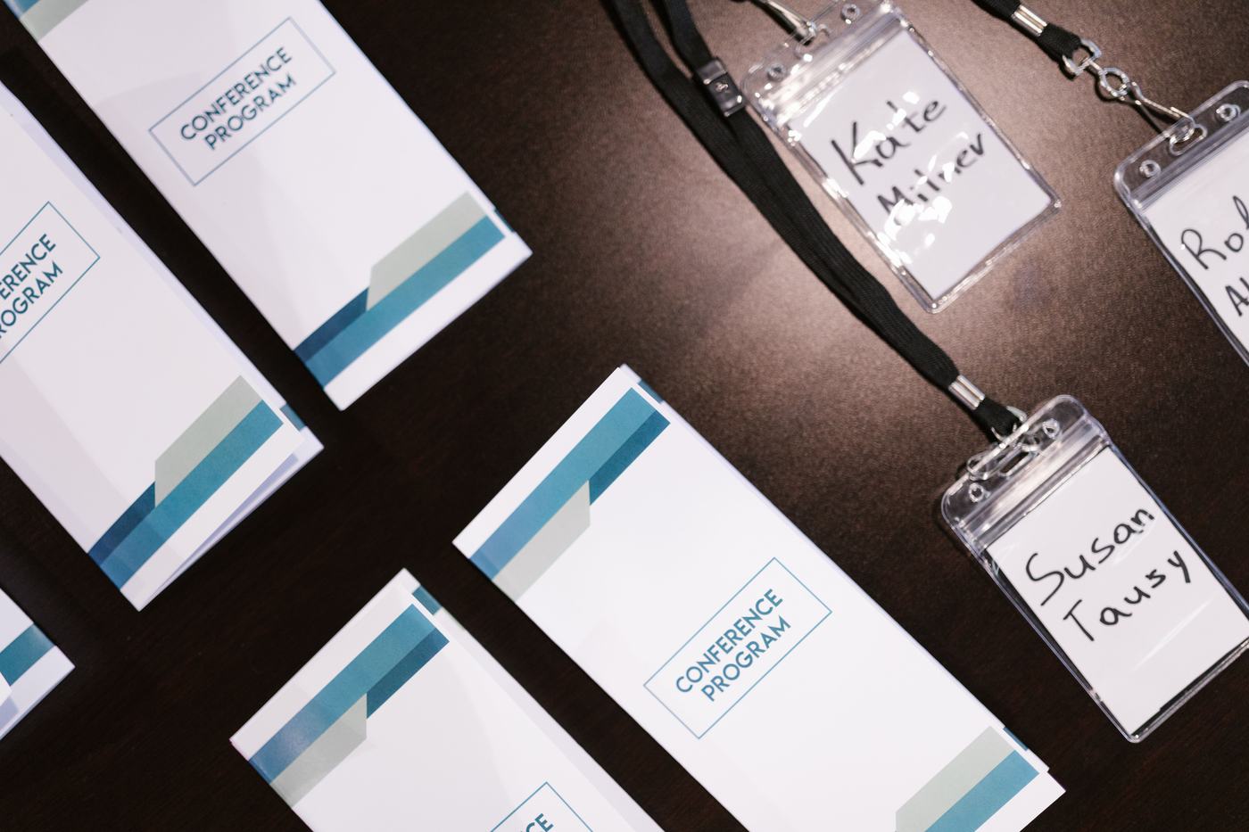 Conference programs and name badges laid out on a registration table